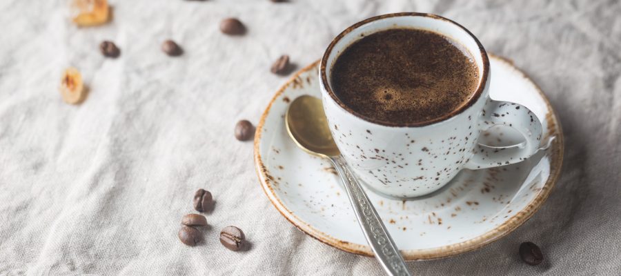 Hot Coffee cup and coffee beans on the wooden table, rustic style